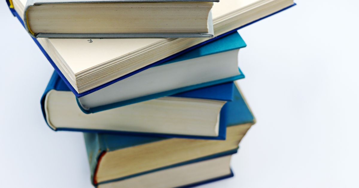 A pile of books with blue covers on a white background, symbolizing education and knowledge.
